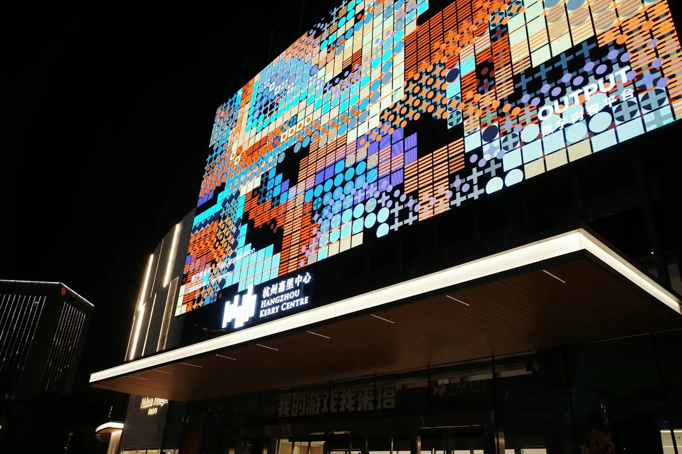 Building facade covered in a large LED display at night