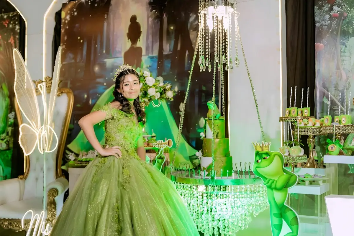Quinceañera in a green gown at a decorated celebration